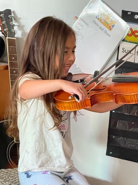 Girl playing violin in the classroom